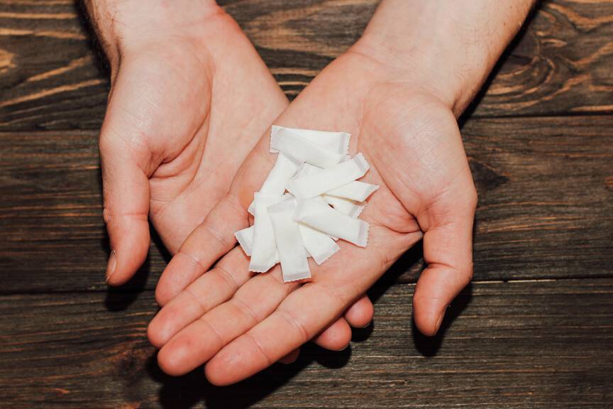 muž drží v rukách vrecká so žuvacím tabakom