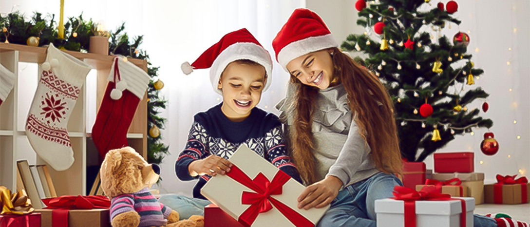 deti pod vianočným stromčekom s darčekmi